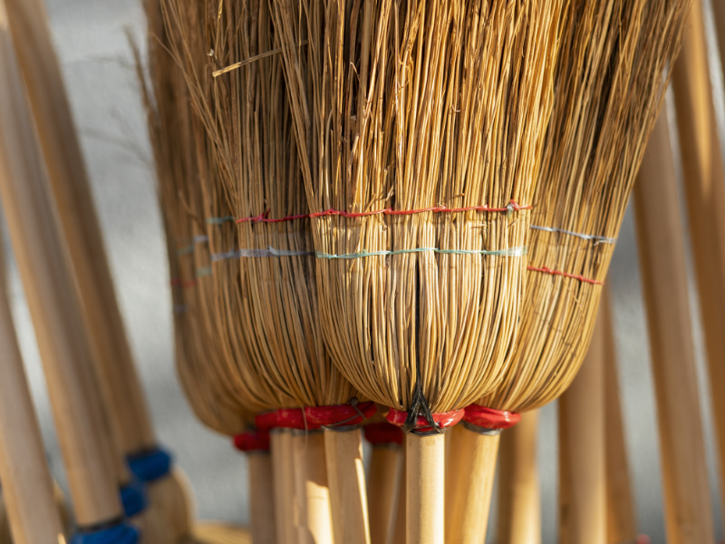 Photograph of several handmade straw brooms